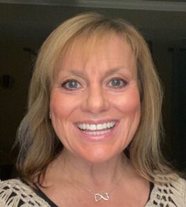 Lynn Makor, white woman, around age 50, blond hair and blue eyes, smiling